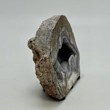 Load image into Gallery viewer, Dugway Geode with internal crystal structure standing on felt tabs