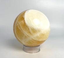 Load image into Gallery viewer, Honeycomb Calcite from Utah carved and polished into a stunning sphere with bright colors and unique pattern