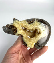 Load image into Gallery viewer, Septarian geode carved and polished into a long neck bear with beautiful calcite crystals in the center