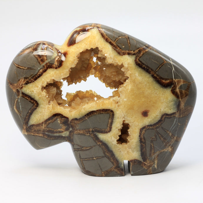 Septarian geode carved and polished into a bison with beautiful calcite crystals in the center