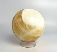 Load image into Gallery viewer, Honeycomb Calcite from Utah carved and polished into a stunning sphere with bright colors and unique pattern
