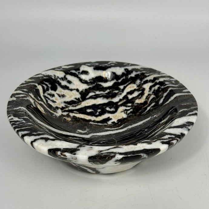 Black and white marbled lapidary shaped and polished bowl on a light gray background