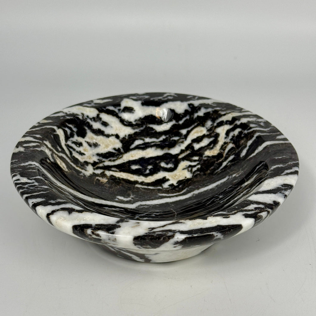 Black and white marbled lapidary shaped and polished bowl on a light gray background