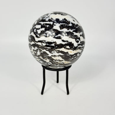 Zebra marble patterned sphere on a black metal stand against a white background