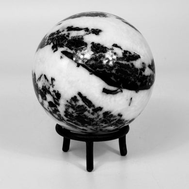 Black and white zebra marble sphere on a stand against a white background