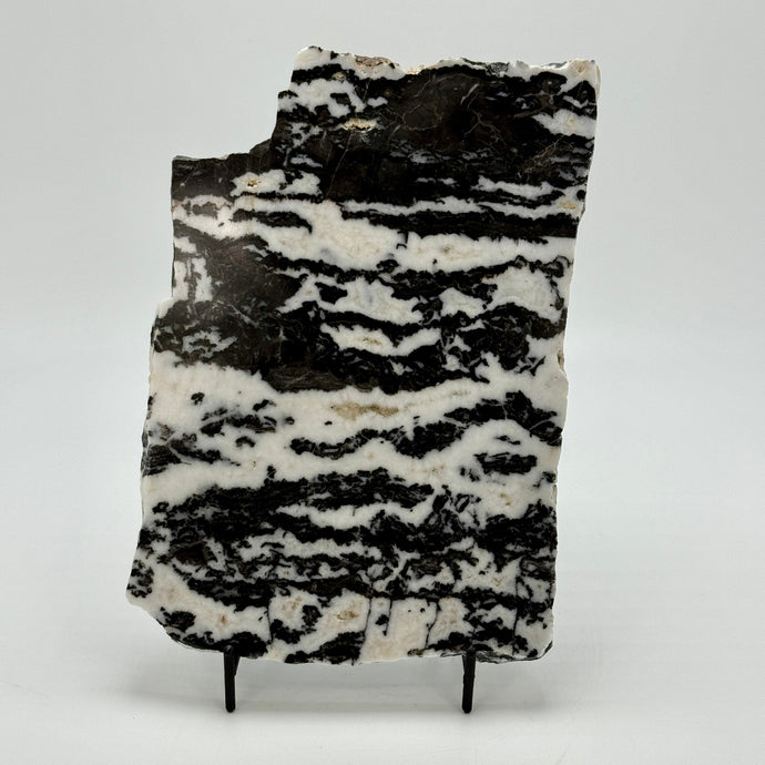 Black and white patterned Zebra marble slab stone on a stand against a white background