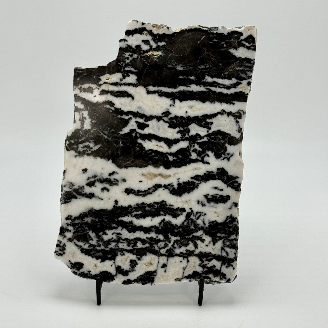 Black and white patterned Zebra marble slab stone on a stand against a white background