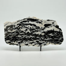 Load image into Gallery viewer, Zebra marble slab with black and white pattern on a stand against a white background
