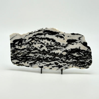 Zebra marble slab with black and white pattern on a stand against a white background