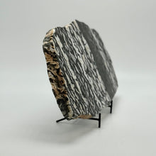 Load image into Gallery viewer, Zebra marble from Utah cut into a slab and highly polished on a stand against a white background
