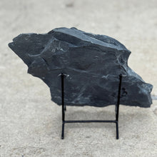 Load image into Gallery viewer, Large dark gray shale stone on a stand against a light gray background
