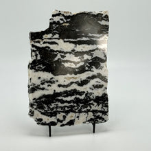 Load image into Gallery viewer, Black and white zebra marbled stone on a stand against a white background
